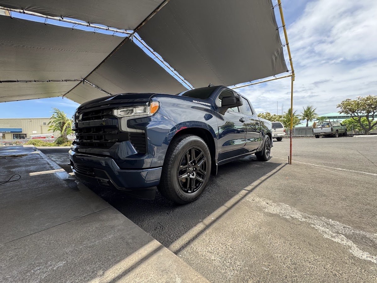 Dark blue Chevrolet Silverado being washed under the SilvaShine tent with a Kona backdrop